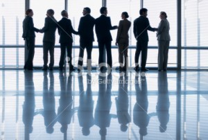 stock-photo-24457759-business-people-shaking-hands-in-a-row-at-lobby-window